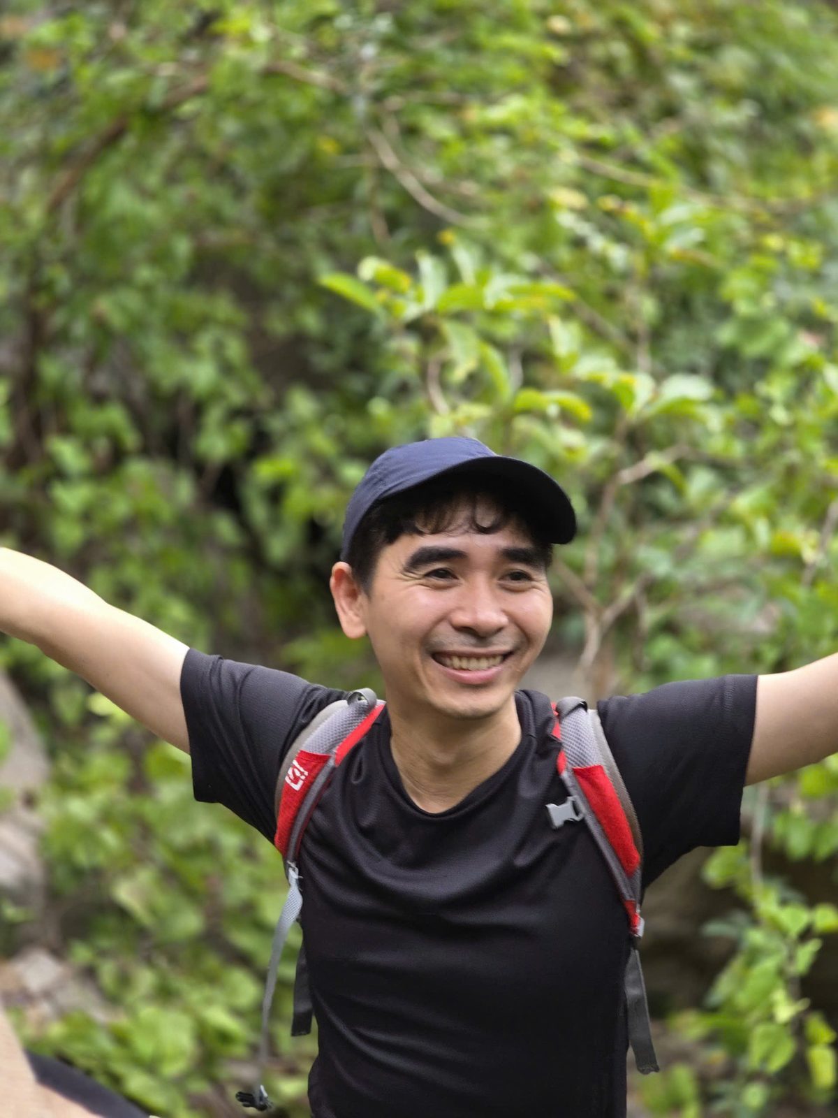 Bùi Văn Hân dang hai tay trên đỉnh núi